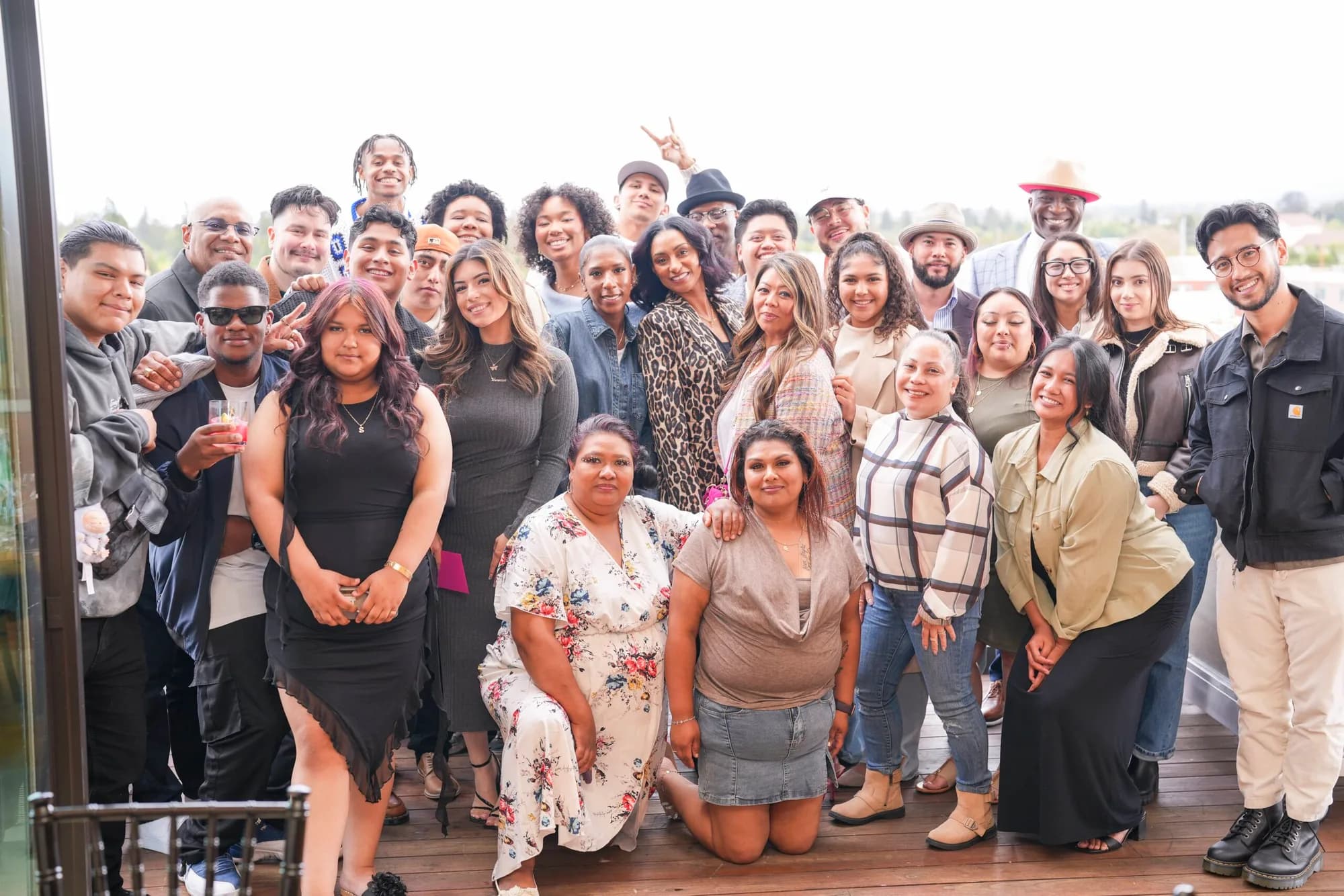 A large group of guests posed together on a rooftop deck